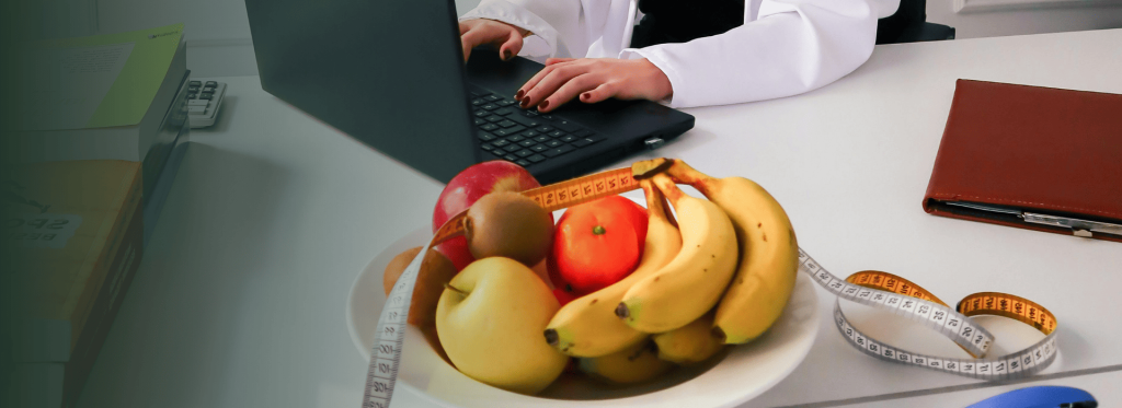 Nutricionista trabajando con frutas y cinta métrica en consulta